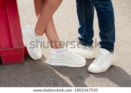 legs close-up of  girl and  guy, concept story, white sneakers on feet