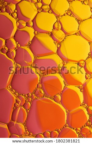 Current collection of brilliant backgrounds for your design. Close-up shot of flattened oil drops on water surface in yellow and orange colors.