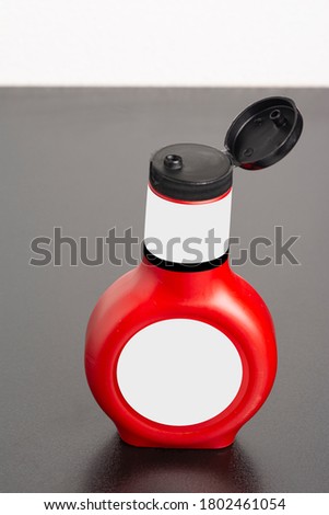 Tomato sauce bottle with cap on black table, editable mock-up series template ready for your design, selection path included. 
