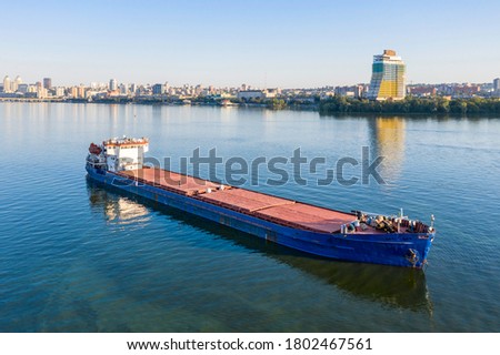 Beautiful blue cargo ship anchored on the Dnieper river against the background of the city of Dnipropetrovsk