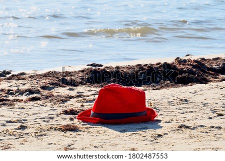 Red hat on the sea sand.