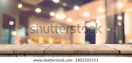 Abstract blurred image of department store with wooden table counter background for show , promote ,design on display concept