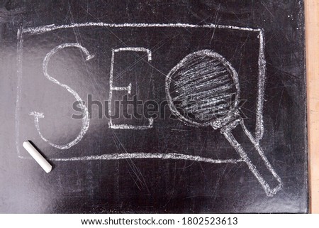 Abbreviation seo written on the blackboard. White chalk on the school board. Search engine optimization concept.