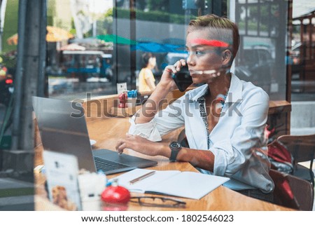 Business woman talking on phone behind glass stock photo