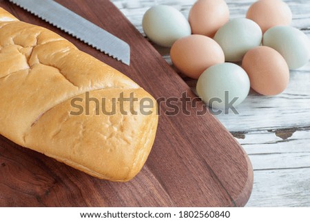 Overhead shot French bread, farm fresh organic eggs and knife for making French toast. Top view, flatlay position.