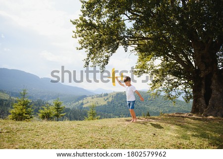 Small Boy Playing with Toy Airplane