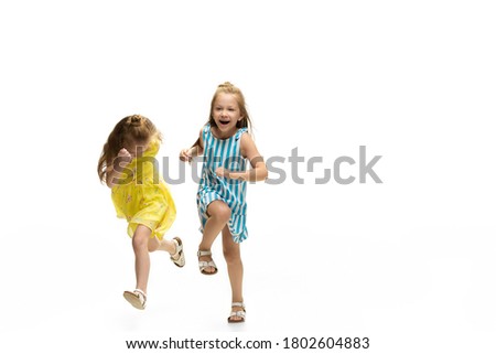 Happy little girls jumping and running on white background, childhood