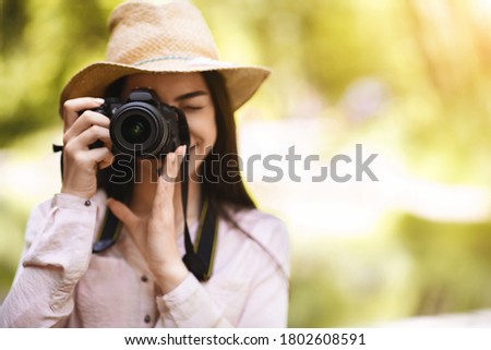 Photography Lover. Young Asian Woman Taking Shot Outdoors With Modern Camera, Focusing On Object, Enjoying Making Photos, Copy Space