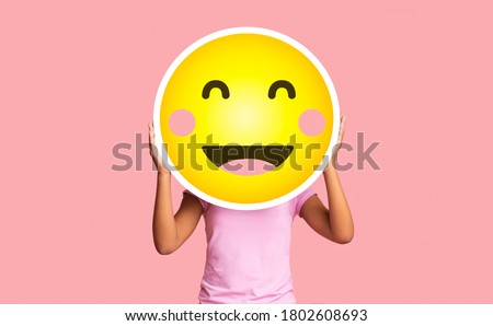 Black girl hiding face behind happy shy emoji emoticon, standing over pink studio background with copy space Royalty-Free Stock Photo #1802608693