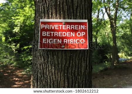 A Dutch warning sign in the forest that says
"Enter private property at your own risk".