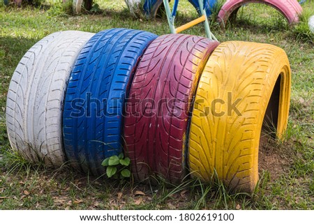 White, blue, red and yellow rubber wheels for children to play in the playground.