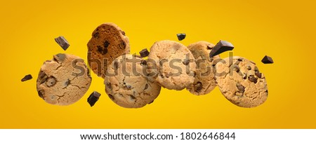 Chocolate chip cookies with pieces of chocolate on yellow background. Royalty-Free Stock Photo #1802646844
