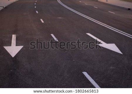 white arrows in the street pointing to you