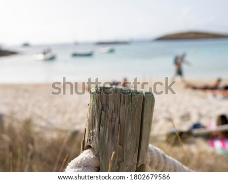 wooden railing with a rope, beach background, summer