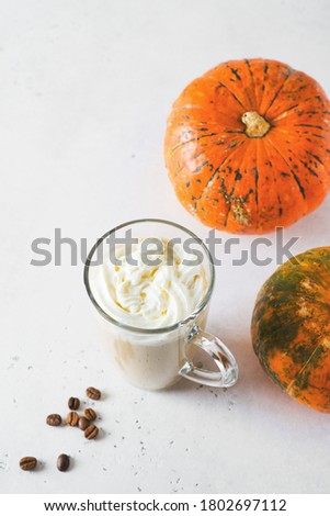 Glass of pumpkin lattee coffee on white background, copy space, top view, vertical