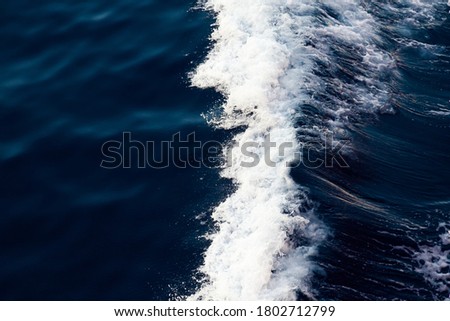 Ocean close up. Background of blue water with white foam.