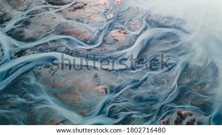 A glacial rivers from above. Aerial photograph of the river streams from Icelandic glaciers. Beautiful art of the Mother nature created in Iceland. Wallpaper background high quality photo Royalty-Free Stock Photo #1802716480