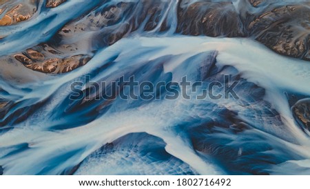 A glacial rivers from above. Aerial photograph of the river streams from Icelandic glaciers. Beautiful art of the Mother nature created in Iceland. Wallpaper background high quality photo Royalty-Free Stock Photo #1802716492