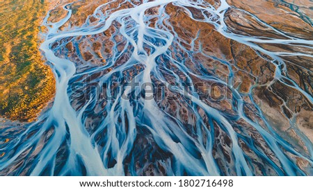 A glacial rivers from above. Aerial photograph of the river streams from Icelandic glaciers. Beautiful art of the Mother nature created in Iceland. Wallpaper background high quality photo Royalty-Free Stock Photo #1802716498