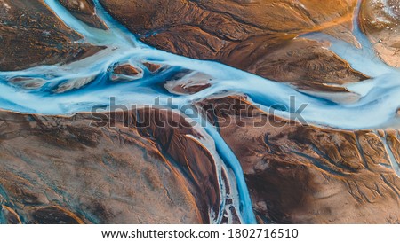 A glacial rivers from above. Aerial photograph of the river streams from Icelandic glaciers. Beautiful art of the Mother nature created in Iceland. Wallpaper background high quality photo Royalty-Free Stock Photo #1802716510