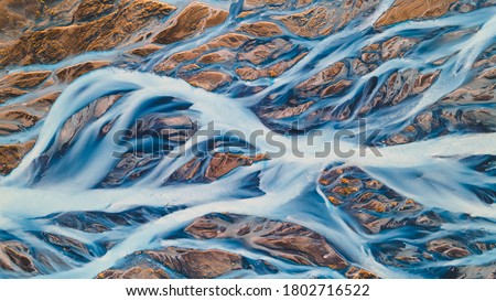 A glacial rivers from above. Aerial photograph of the river streams from Icelandic glaciers. Beautiful art of the Mother nature created in Iceland. Wallpaper background high quality photo Royalty-Free Stock Photo #1802716522