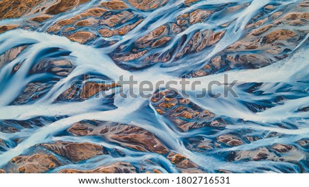 A glacial rivers from above. Aerial photograph of the river streams from Icelandic glaciers. Beautiful art of the Mother nature created in Iceland. Wallpaper background high quality photo Royalty-Free Stock Photo #1802716531