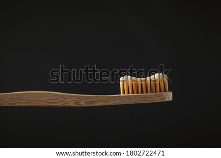 Macro shot of the bamboo toothbrush on the dark background. save the planet