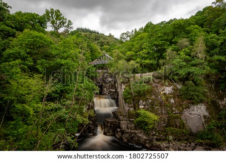 Long exposure picture of a waterfall and bridge in the Scottish highlands