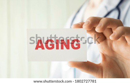 Doctor writing word Aging with marker Medical concept