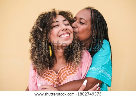 Happy african mother hug and kiss her daughter - Portrait of Mother and adult child love