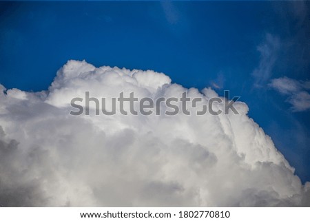 Fluffy clouds cover the summer blue sky