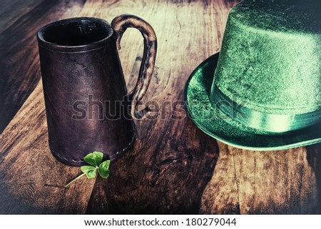 A Saint Patrick's Day background featuring a historic leather mug, green hat, and a shamrock.  Processed for a retro faded look. 
