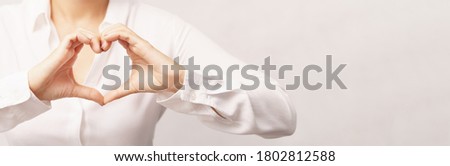 Beautiful woman in white shirt making hands gesture in heart shape showing love, kindness, appreciation and support. Health care, Charity, Organ donation and World heart day concept. Royalty-Free Stock Photo #1802812588