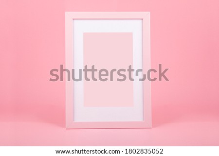 Decorative pink wooden picture frame over pink background