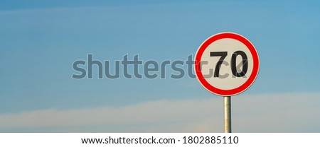 70 speed limit road sign over blue sky background