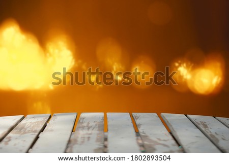 Wooden table and orange bokeh background