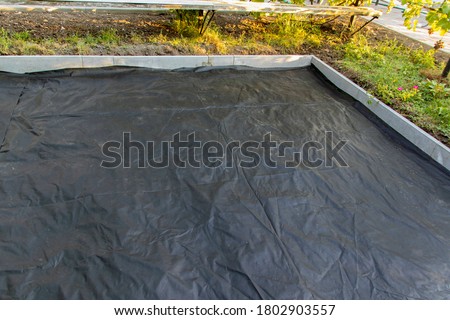 The base for tiling is prepared using a membrane that suppresses the growth of weeds and prevents mixing of rubble and earth. Selective focus.
 Royalty-Free Stock Photo #1802903557