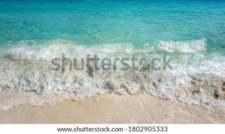 Blue sea water with waves and sand beach.