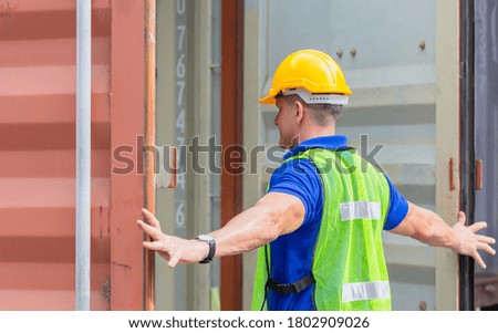 Engineer worker man in hardhat and safety vest checking containers box from cargo