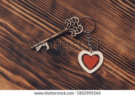 Old key with a heart on white wood . sweet home concept. 