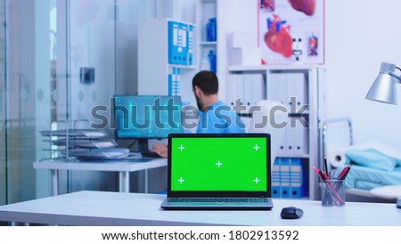 Health physician leaving clinic cabinet and laptop with copy space available while nurse typing notes on computer. Notebook with replaceable screen in medic clinic.