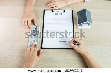 Buyer hand signs contract after Real estate agents explains a business contract, lease, purchase, mortgage, loan, or home insurance.
