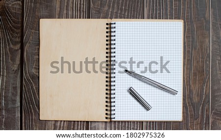 notebook and pen on wood background