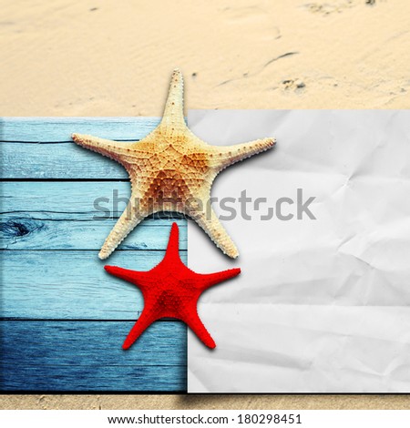 Star fish and paper on wooden floor and sand
