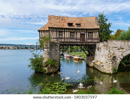 The Old mill (le vieux moulin) on the Vernon broken bridge on Seine river with swans in foreground- Vernon, Normandy, France
