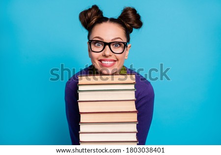 Photo of pretty student lady two funny buns leaning head chin books pile diligent pupil visit library fond of reading wear shirt pullover specs isolated blue color background