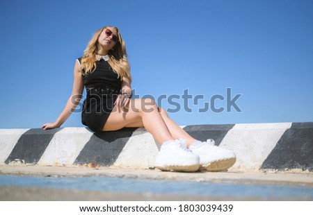 Woman in dress enjoys sea on the pier.