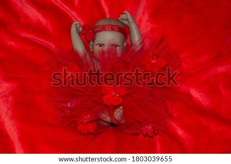 Realistic newborn baby doll in red dress