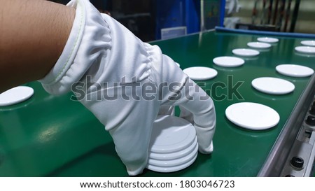 White glove with round plastic handle in working line
.