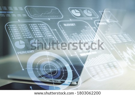 Multi exposure of creative statistics data hologram on laptop background, stats and analytics concept